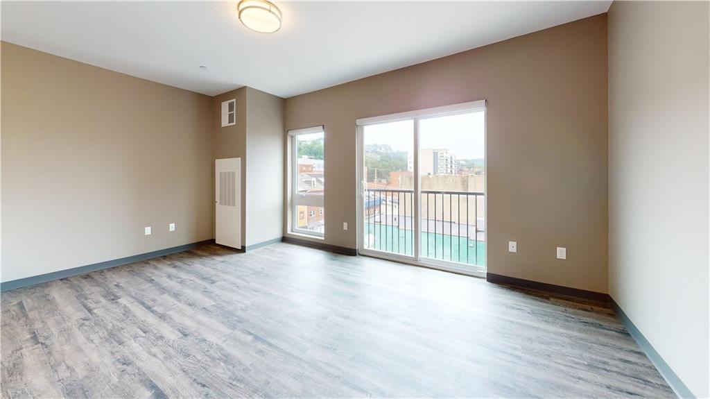 1450 Fifth Avenue, Unit 202 Pittsburgh, PA 15219 - Photo 11 of 20 a view of an empty room with wooden floor and a window