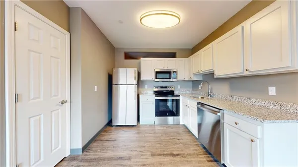 a kitchen with stainless steel appliances granite countertop a refrigerator and a stove top oven