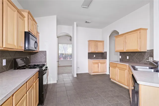 a kitchen with a sink a stove and cabinets