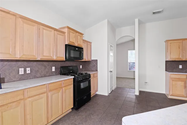 a kitchen with stainless steel appliances granite countertop a refrigerator stove and sink