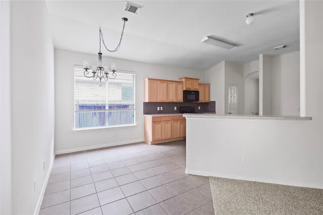 a kitchen with granite countertop a stove a sink a counter space and cabinets