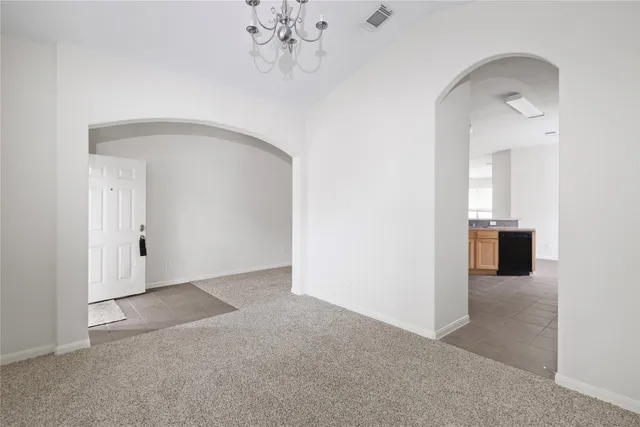 an empty room with chandelier fan
