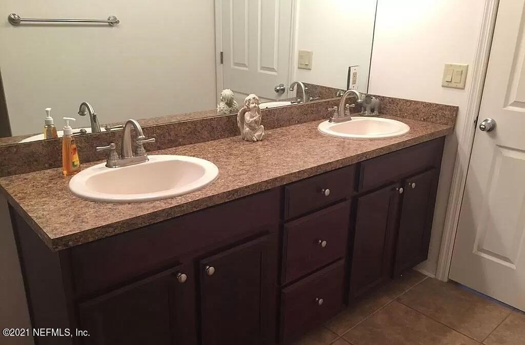 2346 Somerset Road Jacksonville, FL 32210 - Photo 18 of 23 a bathroom with a granite countertop sink and a mirror
