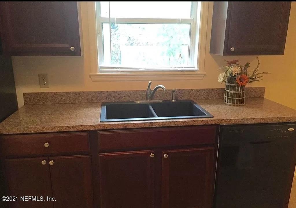 2346 Somerset Road Jacksonville, FL 32210 - Photo 23 of 23 a kitchen with a sink a window and cabinets
