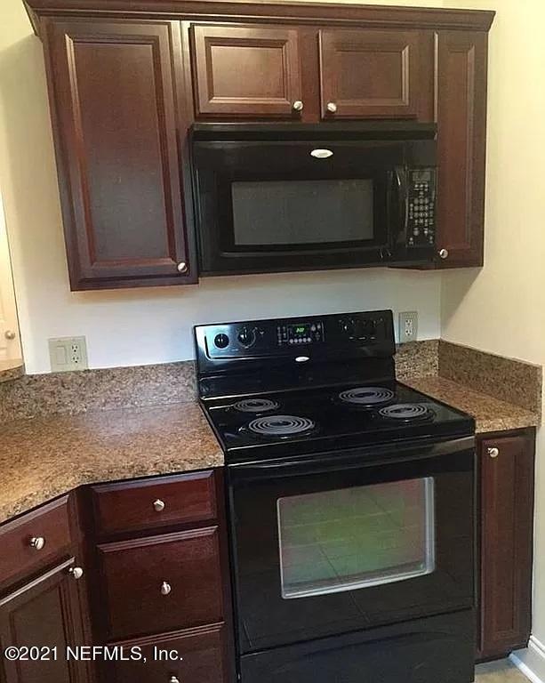 2346 Somerset Road Jacksonville, FL 32210 - Photo 4 of 23 a kitchen with a stove and a microwave