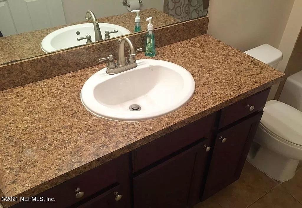 2346 Somerset Road Jacksonville, FL 32210 - Photo 9 of 23 a bathroom with a granite countertop sink and a mirror