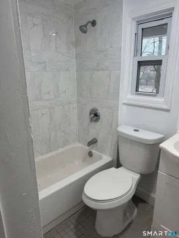 a white toilet sitting next to a bath tub