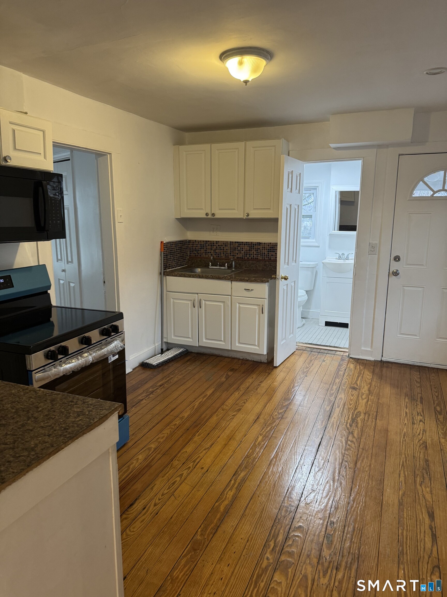 Undisclosed Address Ansonia, CT 06401 - Photo 4 of 20 a kitchen with granite countertop a stove and a wooden floors