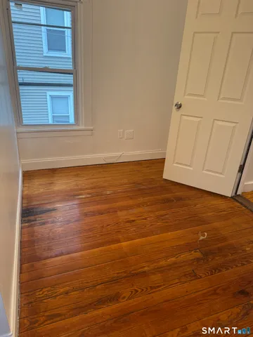 a view of a room with an empty space and wooden floor