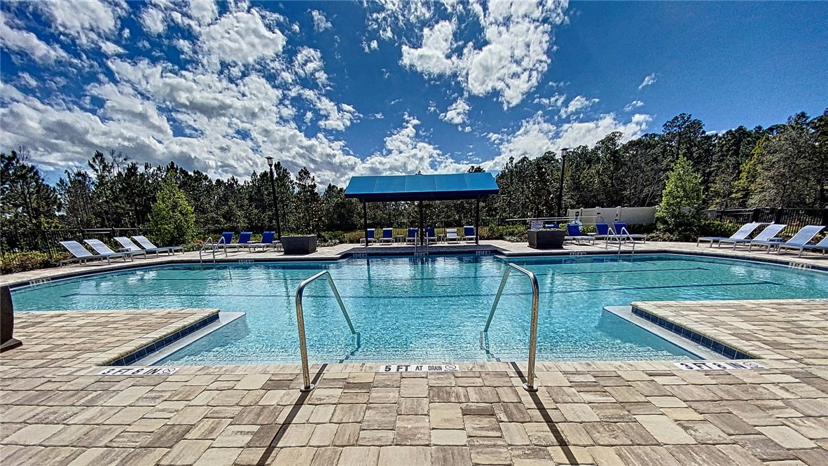 93015 Cope Court Fernandina Beach, FL 32034 - Photo 16 of 23 a view of a swimming pool with a lounge chairs in front of a house
