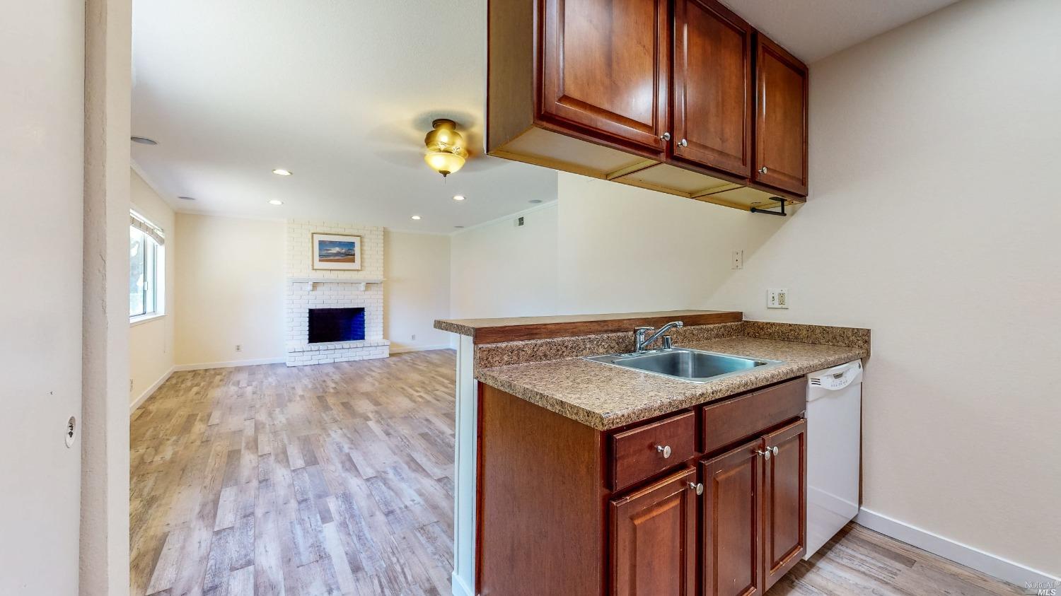 a kitchen with a sink a stove cabinets and a wooden floor