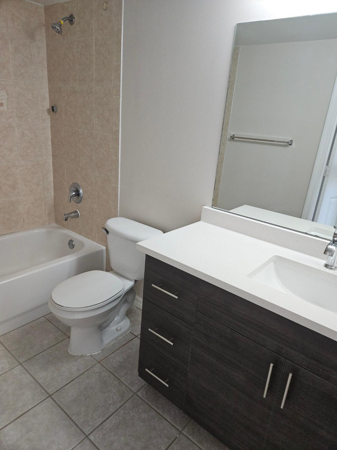5011 Wiles Road, Unit 308 Coconut Creek, FL 33073 - Photo 3 of 12 a bathroom with a sink a toilet and bathtub
