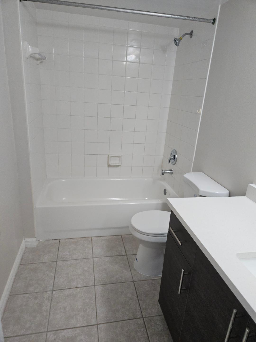 5011 Wiles Road, Unit 308 Coconut Creek, FL 33073 - Photo 4 of 12 a bathroom with a sink a toilet and shower