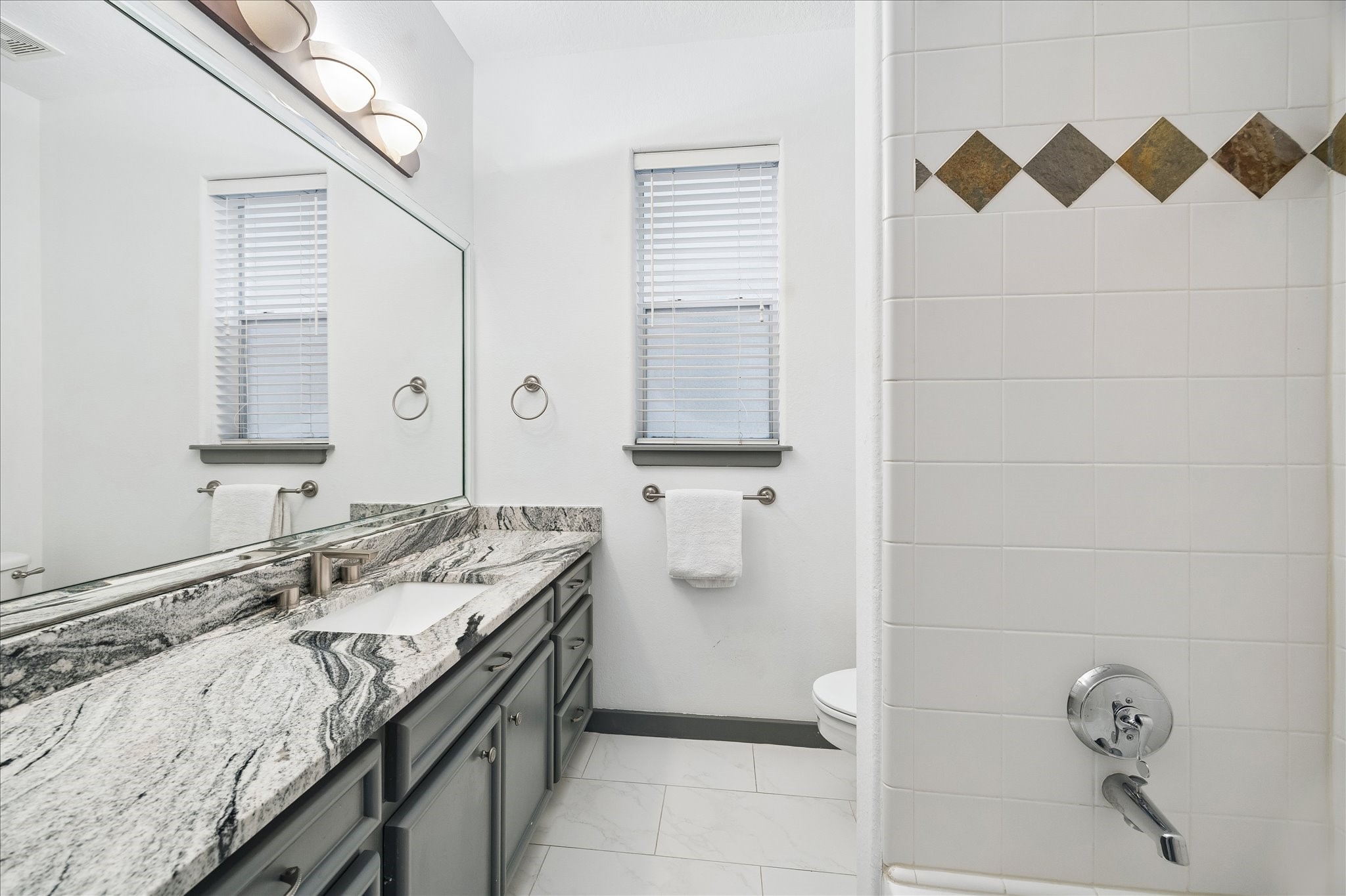 6406 Rodrigo Street, Unit B Houston, TX 77007 - Photo 4 of 27 First floor bathroom features a single vanity with storage, shower/tub combination and tile flooring.