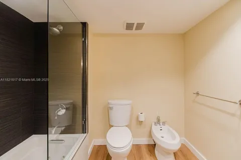 a bathroom with a granite countertop sink toilet and mirror