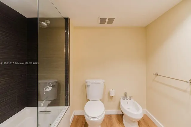 a bathroom with a granite countertop sink toilet and mirror