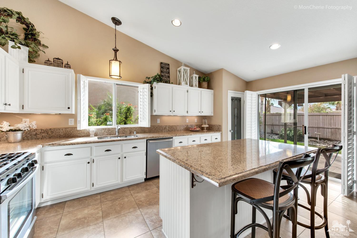 41675 Front Hall Road Bermuda Dunes, CA 92203 - Photo 7 of 23 a kitchen with granite countertop a table chairs sink and cabinets