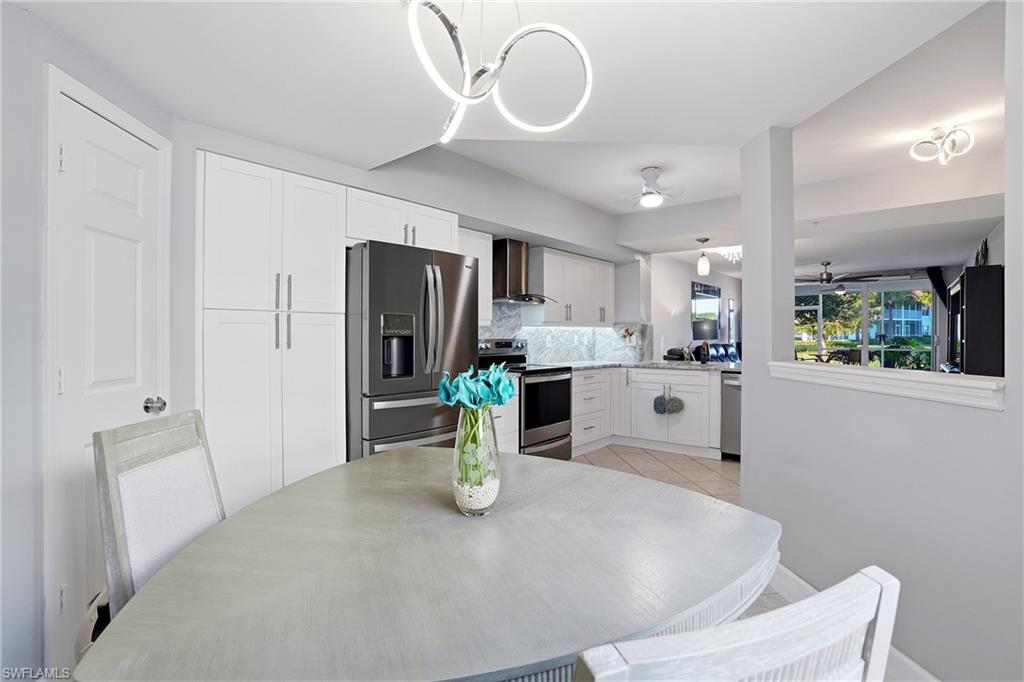 a kitchen with stainless steel appliances kitchen island granite countertop a refrigerator a stove a microwave oven a sink with island and chairs