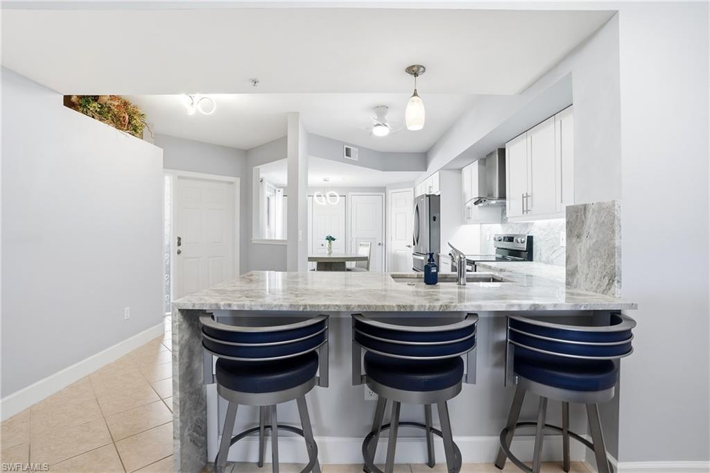 4950 Deerfield Way, Unit 103 Naples, FL 34110 - Photo 12 of 39 a kitchen with sink and cabinets