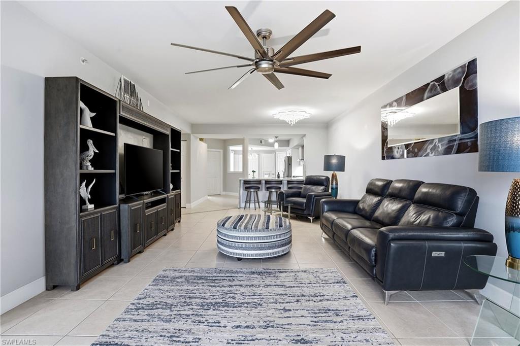 4950 Deerfield Way, Unit 103 Naples, FL 34110 - Photo 16 of 39 a living room with furniture and a flat screen tv