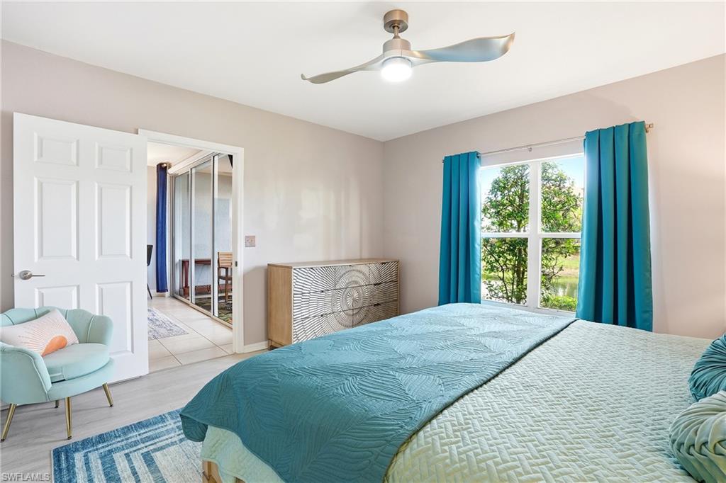 4950 Deerfield Way, Unit 103 Naples, FL 34110 - Photo 18 of 39 a spacious bedroom with a bed a table and chair