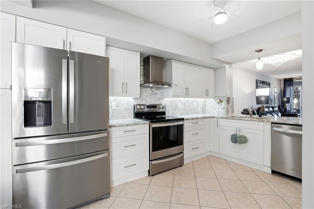 4950 Deerfield Way, Unit 103 Naples, FL 34110 - Photo 2 of 39 a kitchen with stainless steel appliances granite countertop a refrigerator and a stove top oven