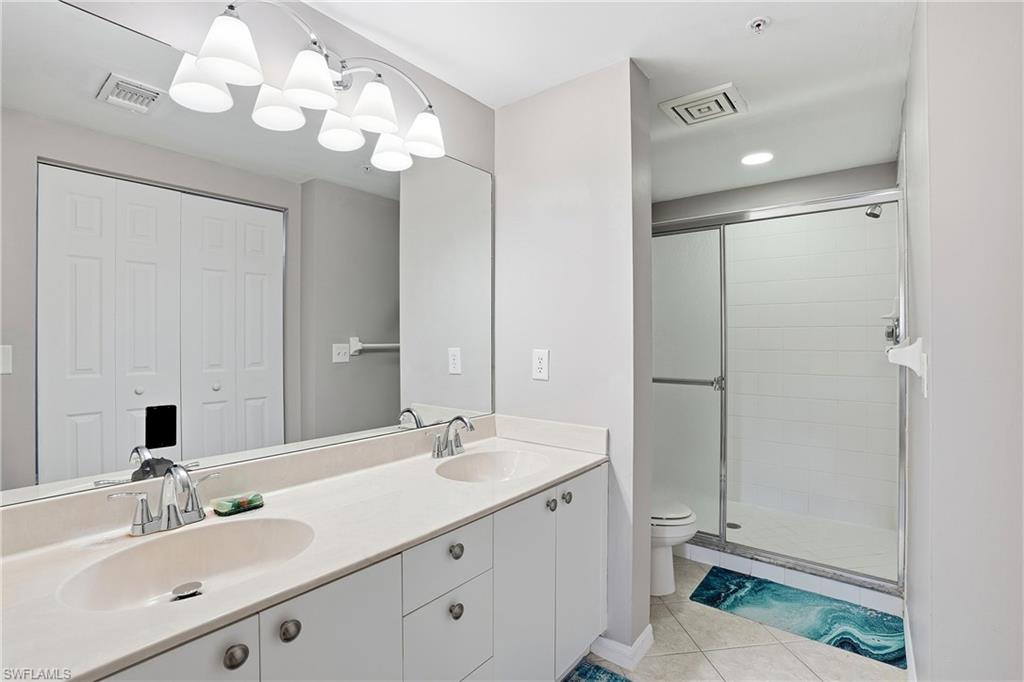 4950 Deerfield Way, Unit 103 Naples, FL 34110 - Photo 21 of 39 a bathroom with a sink vanity and a mirror