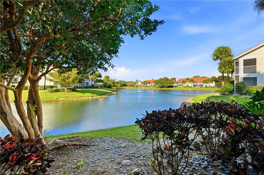 4950 Deerfield Way, Unit 103 Naples, FL 34110 - Photo 26 of 39 a view of a lake with a building in the background