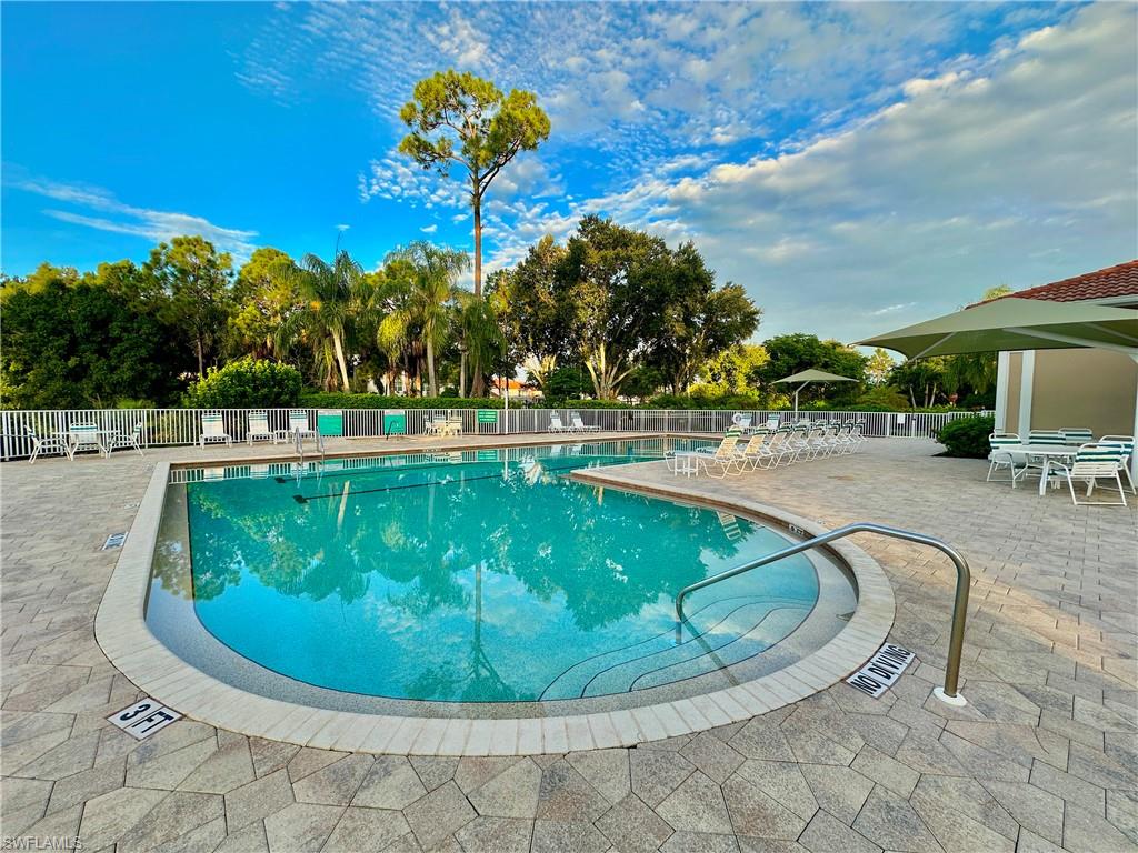 4950 Deerfield Way, Unit 103 Naples, FL 34110 - Photo 35 of 39 a view of a swimming pool with a sitting space
