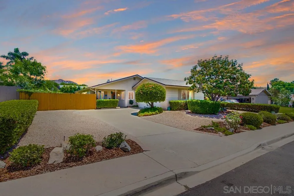 front view of a house with a yard and potted plants