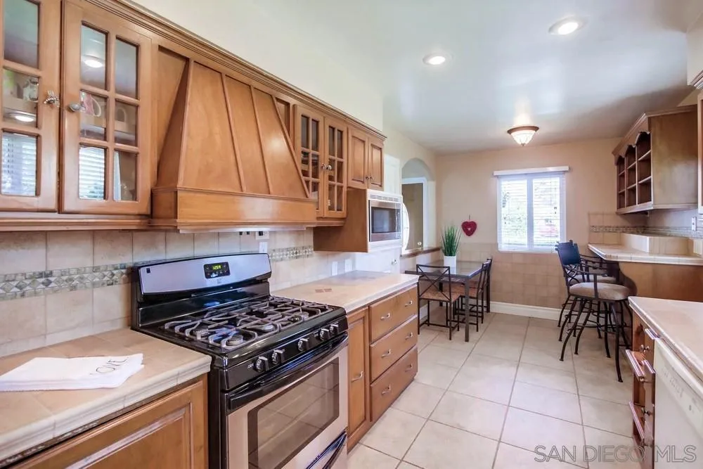 14655 Evening Star Drive Poway, CA 92064 - Photo 17 of 33 a kitchen with stainless steel appliances granite countertop a stove a sink and a microwave