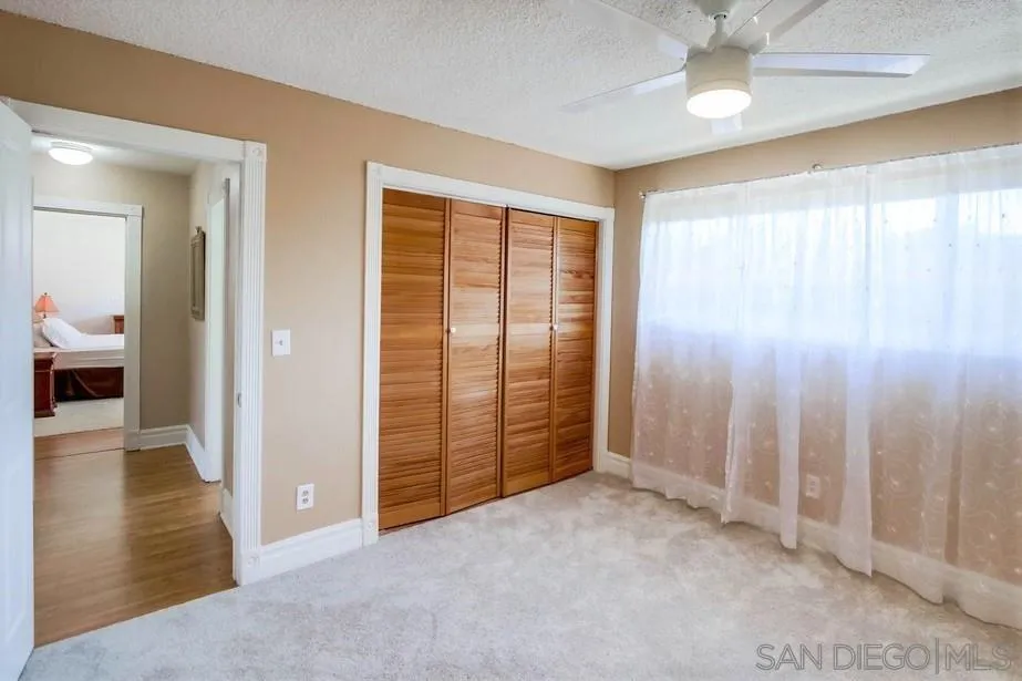 14655 Evening Star Drive Poway, CA 92064 - Photo 30 of 33 an empty room with wooden floor and windows with curtains
