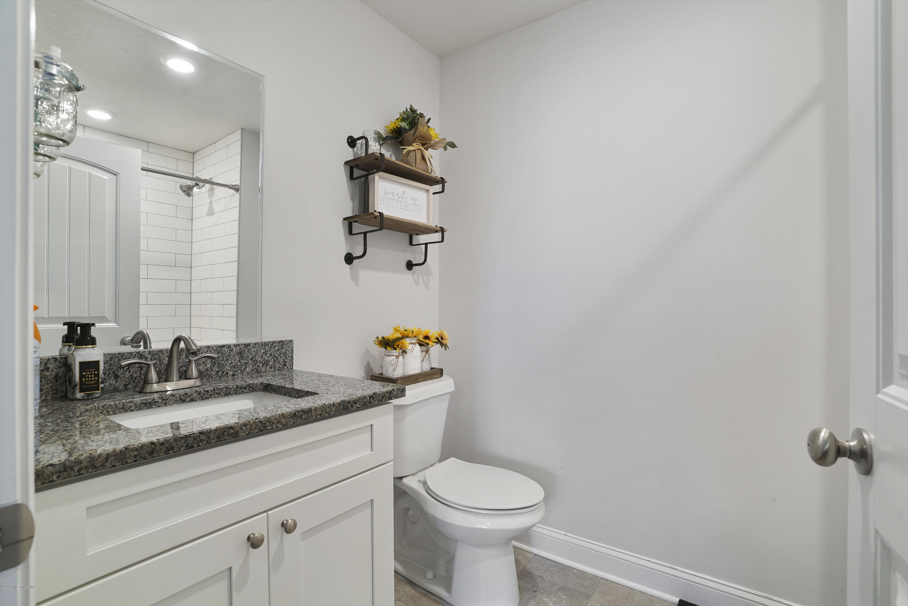 54096 Jeannie Road Callahan, FL 32011 - Photo 13 of 19 a bathroom with a granite countertop sink a toilet and mirror