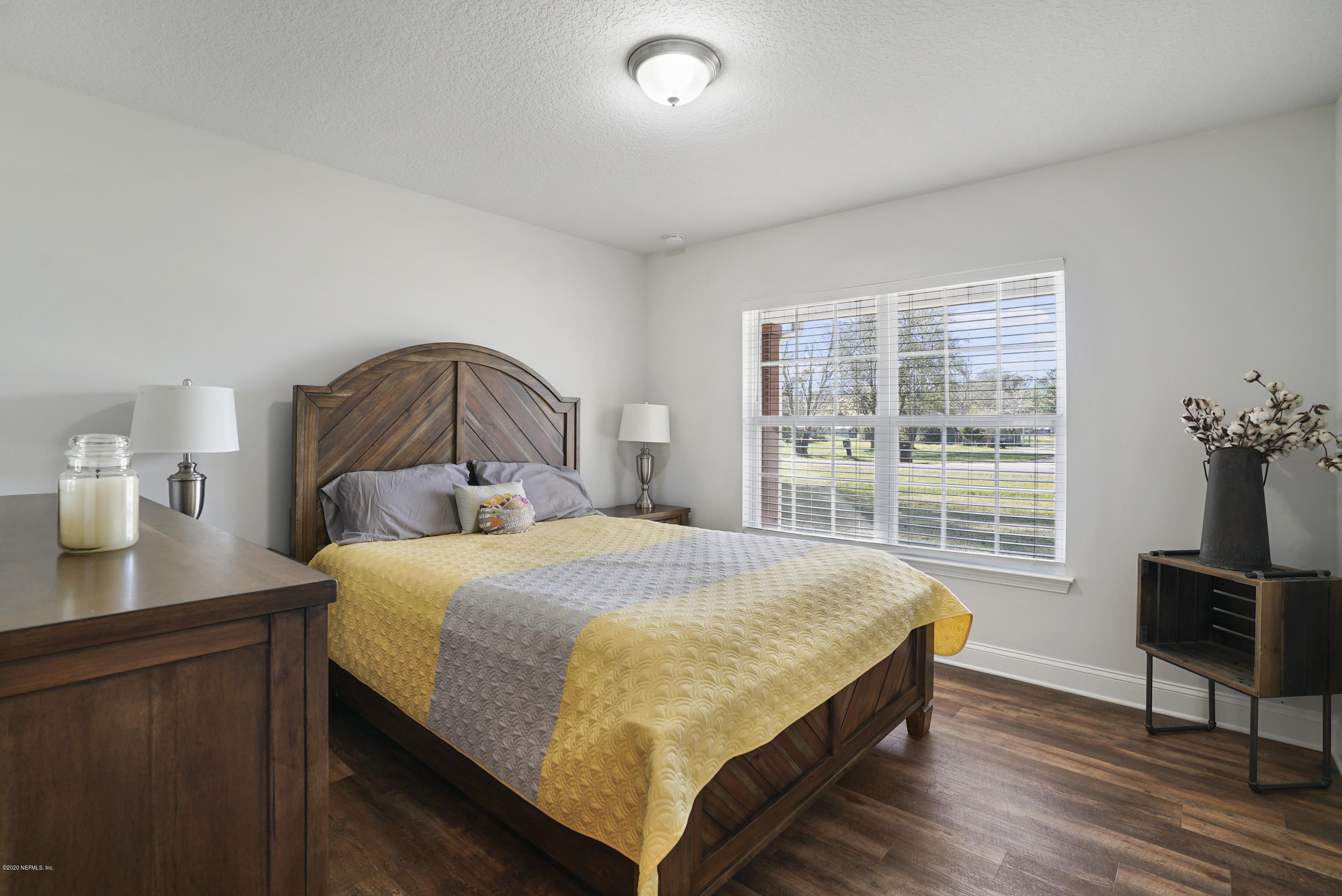 54096 Jeannie Road Callahan, FL 32011 - Photo 14 of 19 a bedroom with a bed a table and a dresser next to a window