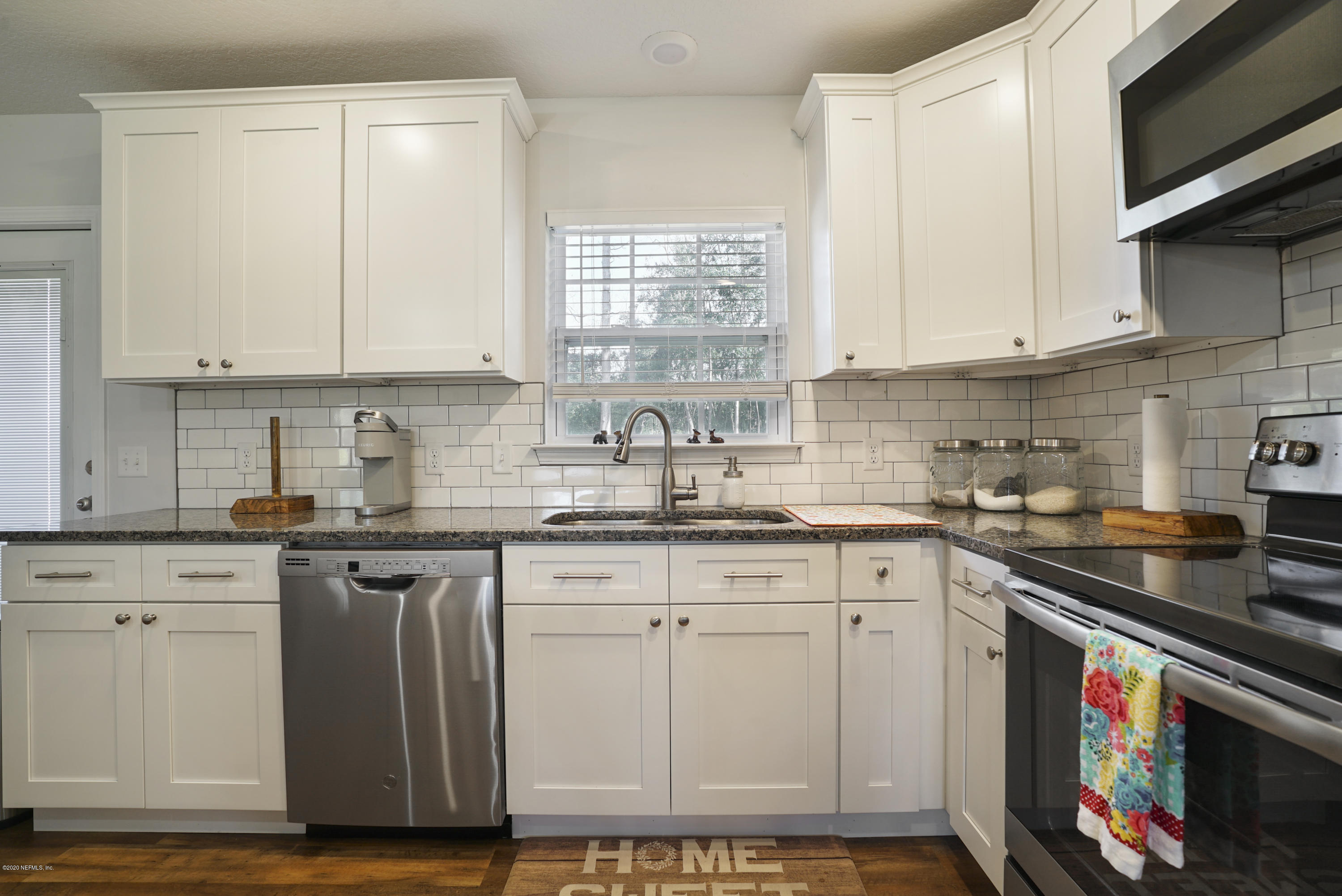 54096 Jeannie Road Callahan, FL 32011 - Photo 8 of 19 a kitchen with stainless steel appliances granite countertop a stove a sink and a microwave