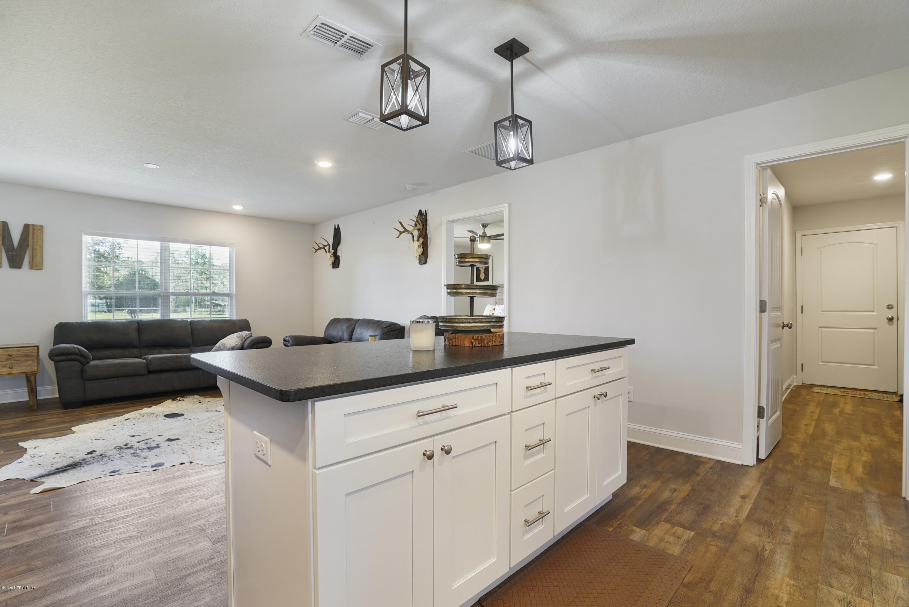 54096 Jeannie Road Callahan, FL 32011 - Photo 9 of 19 a kitchen with stainless steel appliances granite countertop white cabinets and window