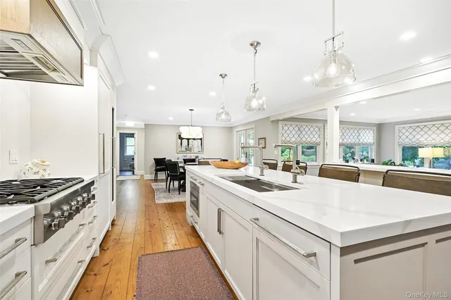 a large kitchen with kitchen island a stove a sink a refrigerator and a view of living room