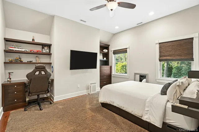 a bedroom with a bed window and a flat screen tv