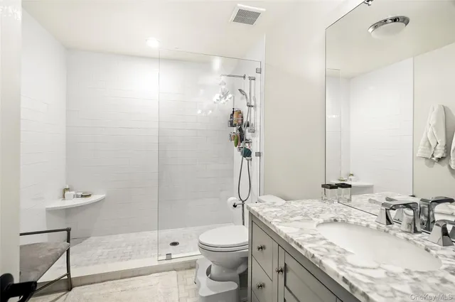 a bathroom with a granite countertop sink toilet and shower