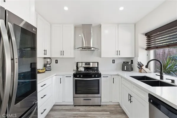a kitchen with white cabinets and stainless steel appliances