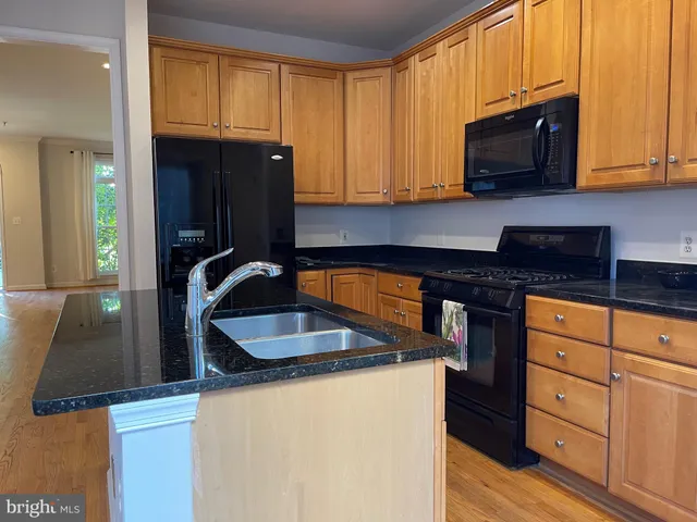 a kitchen with granite countertop a sink stove and cabinets