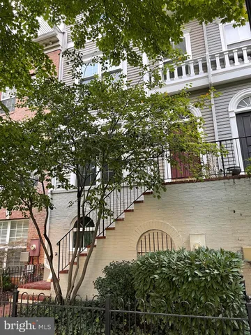 a kitchen with granite countertop wooden cabinets a stove top oven a sink and a window