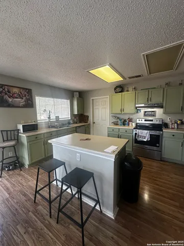 a kitchen with a table chairs stove and cabinets