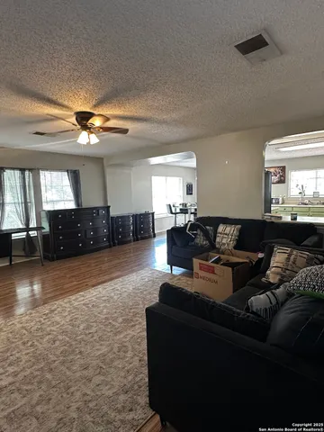 a living room with furniture and a wooden floor