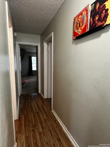 a view of a hallway with wooden floor