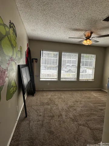 a view of an empty room with a fireplace and a window
