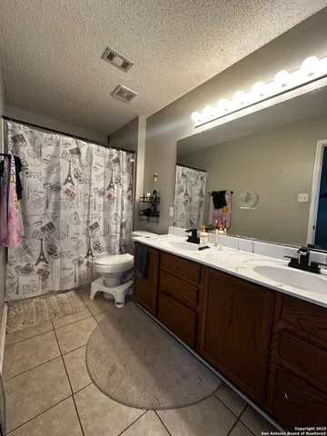 a spacious bathroom with a double vanity sink toilet and a shower