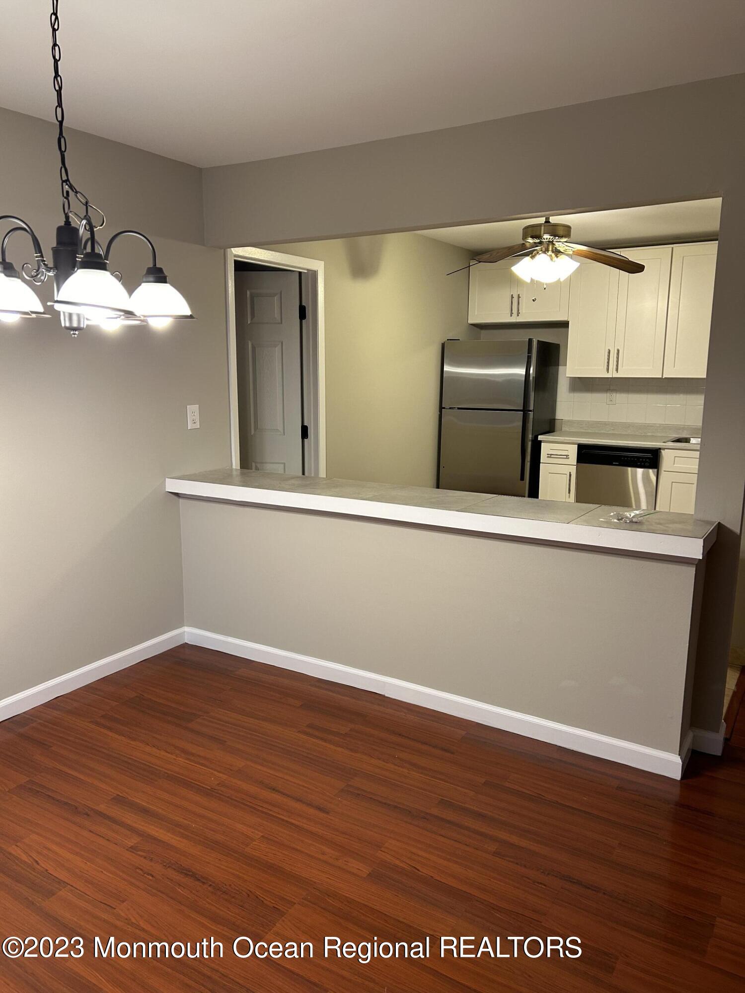 136 Amberly Drive, Unit F Manalapan, NJ 07726 - Photo 6 of 14 a view of kitchen with granite countertop cabinets and wooden floor