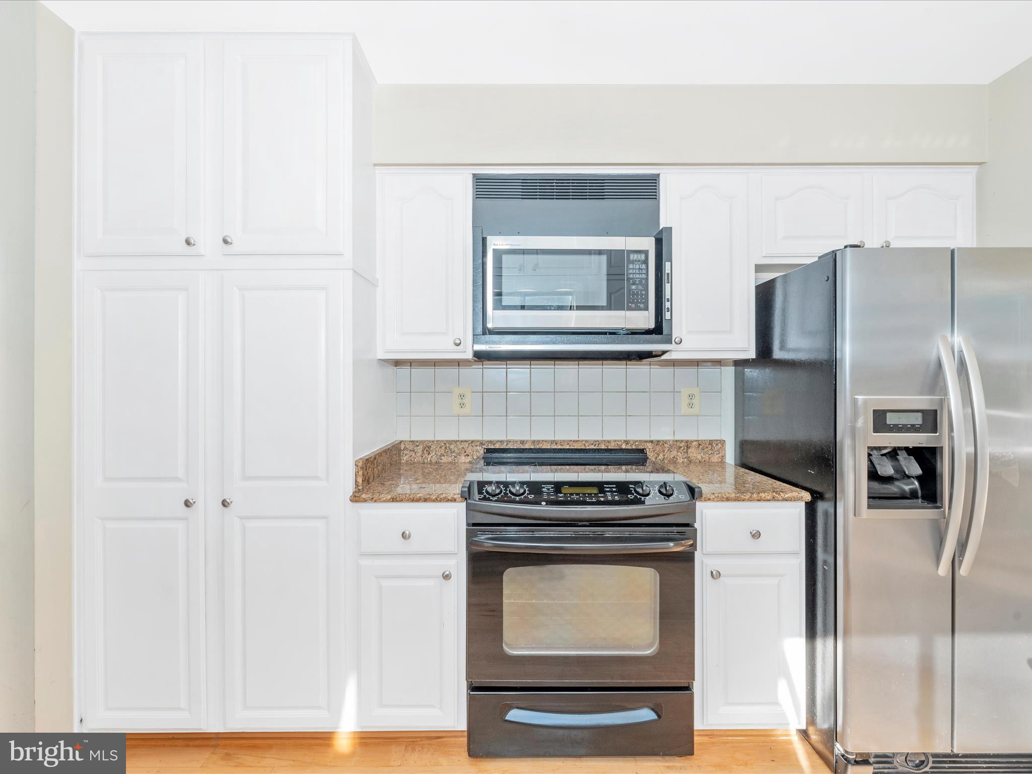 5169 Perry Road Mount Airy, MD 21771 - Photo 16 of 60 a kitchen with stainless steel appliances a refrigerator a stove and white cabinets