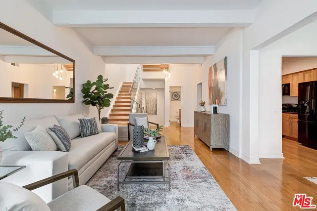 a living room with furniture wooden floor and a large window